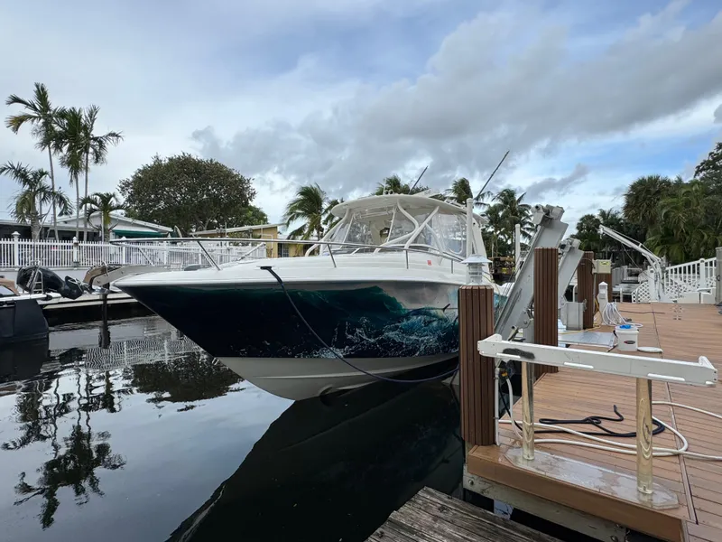 Slide: The Image of 2010 Hydra-Sports 3500 VX boat docked by a wooden pier, surrounded by palm trees. - 4