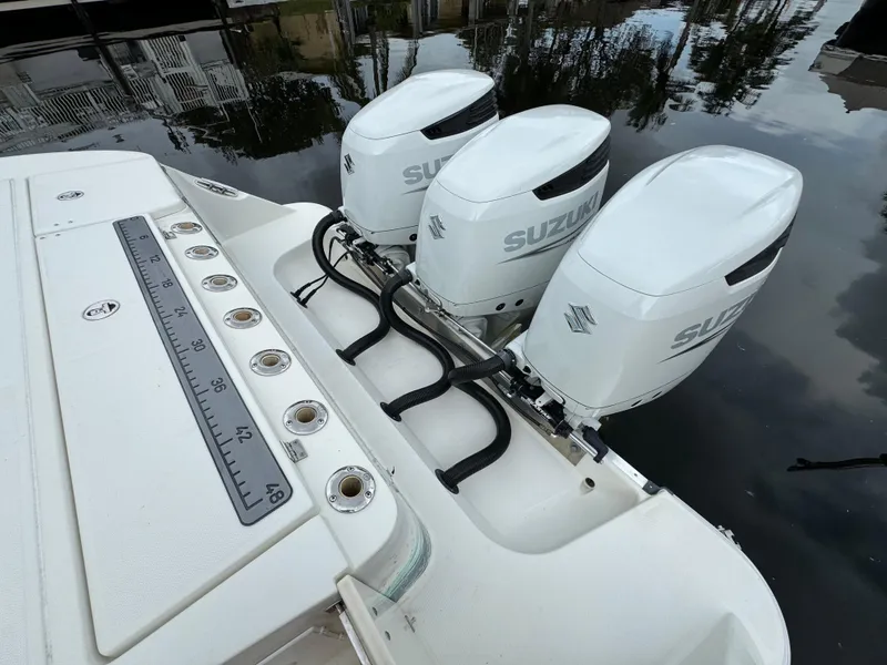 Slide: The Image of 2010 Hydra-Sports 3500 VX boat with triple Suzuki outboard motors on calm water. - 8