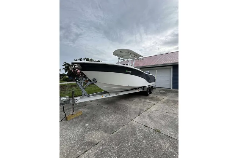 Slide: The Image of 2017 Sea Fox 266 Commander boat on trailer, parked near a garage. - 0
