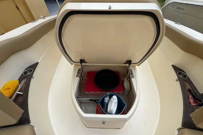 Slide: The Image of 2020 Scout 235 XSF boat storage compartment with cleaning supplies and accessories. - 12