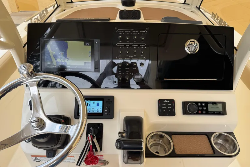 Slide: The Image of 2020 Scout 235 XSF boat dashboard with steering wheel, navigation controls, and display screens. - 17