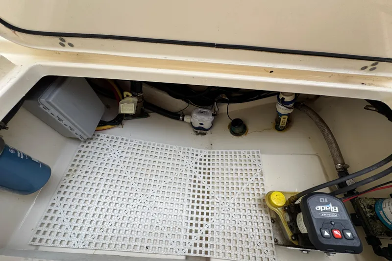 Slide: The Image of 2020 Scout 235 XSF boat compartment with wiring, pump, and control panel. - 27