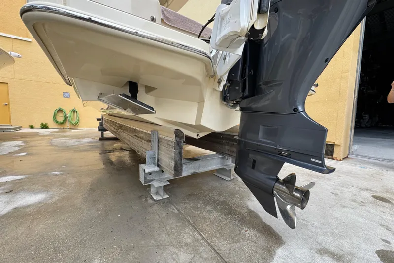 Slide: The Image of 2020 Scout 235 XSF boat on a lift, showcasing the outboard motor and hull. - 30