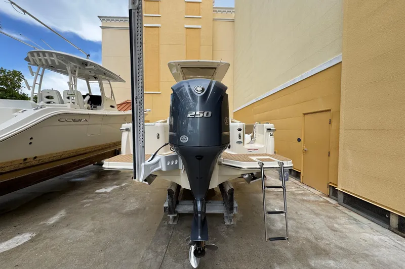 Slide: The Image of 2020 Scout 235 XSF boat with Yamaha 250 engine, parked beside a building. - 31