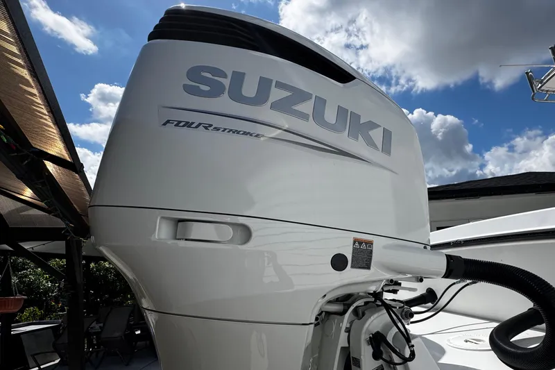 Slide: The Image of Suzuki four-stroke engine on 2022 Whitewater 28 Open boat under a cloudy sky. - 12