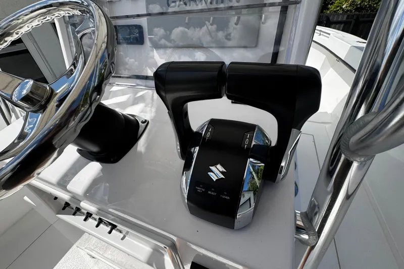 Slide: The Image of 2022 Whitewater 28 Open boat helm with Suzuki controls and steering wheel. - 19