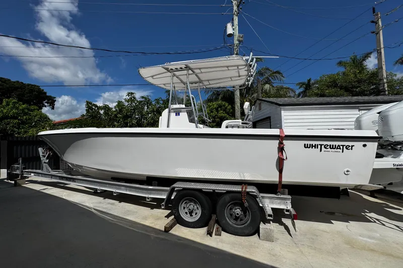 Slide: The Image of 2022 Whitewater 28 Open boat on trailer, parked outdoors under clear sky. - 7