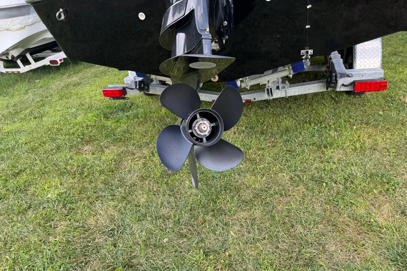 Slide: The Image of 2020 Hurricane SunDeck 191 OB boat propeller on grass near trailer. - 4