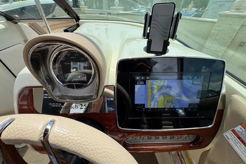 Slide: The Image of 2023 Chris-Craft Launch 25 GT dashboard with speedometer and Garmin navigation display. - 13