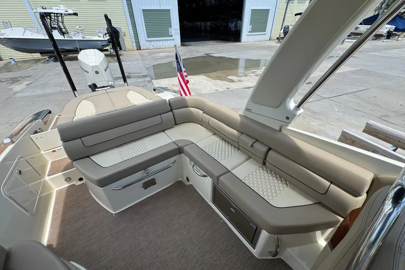 Slide: The Image of 2023 Chris-Craft Launch 25 GT boat interior with beige seating and American flag. - 16