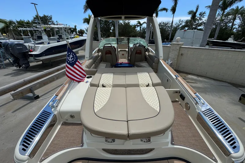 Slide: The Image of 2023 Chris-Craft Launch 25 GT boat with elegant seating and American flag. - 21