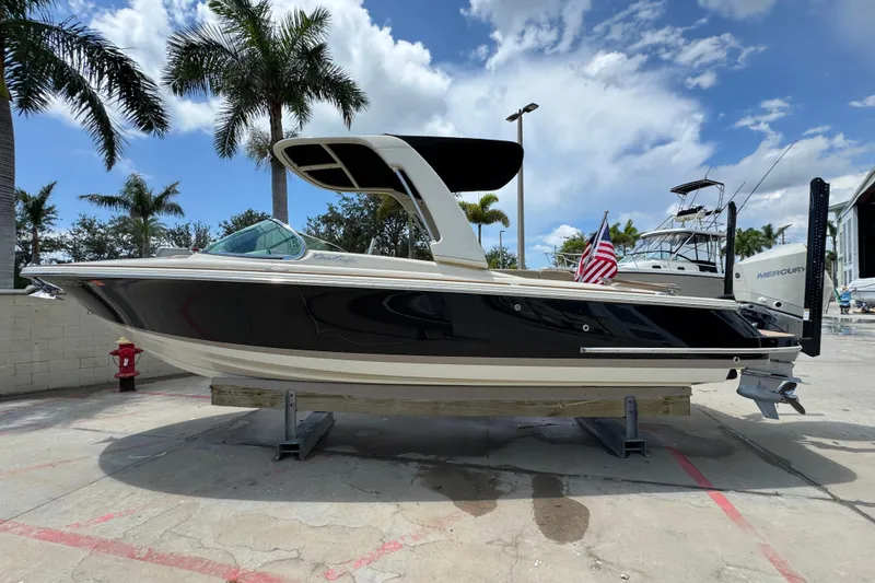 Slide: The Image of 2023 Chris-Craft Launch 25 GT boat displayed outdoors with palm trees and blue sky. - 3