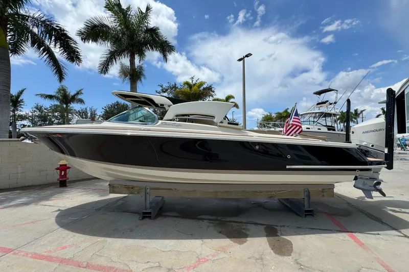 Slide: The Image of 2023 Chris-Craft Launch 25 GT boat displayed outdoors with palm trees and blue sky. - 4