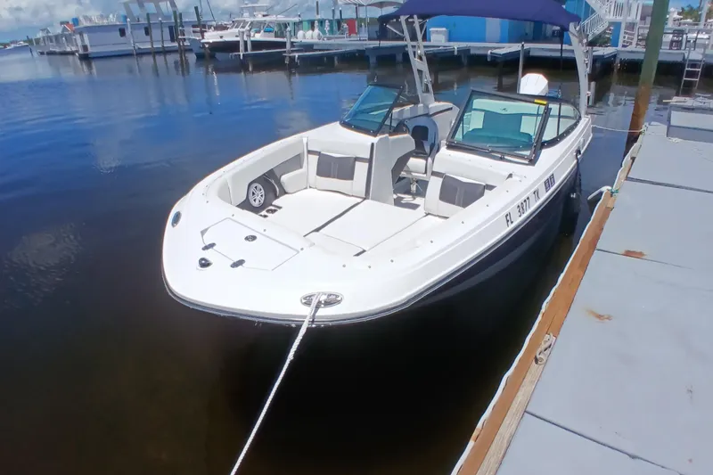 Slide: The Image of 2023 Monterey 225 boat docked at marina, featuring sleek design and spacious seating. - 7
