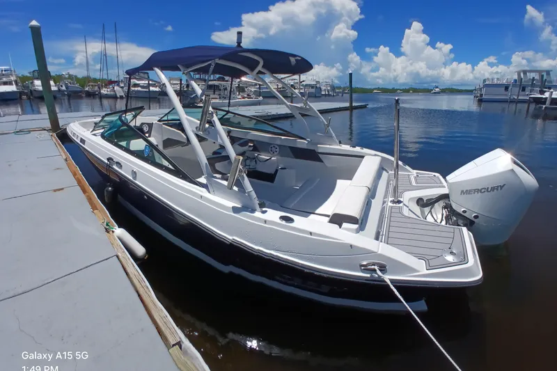 Slide: The Image of 2023 Monterey 225 boat docked, featuring a Mercury outboard motor and sleek design. - 9