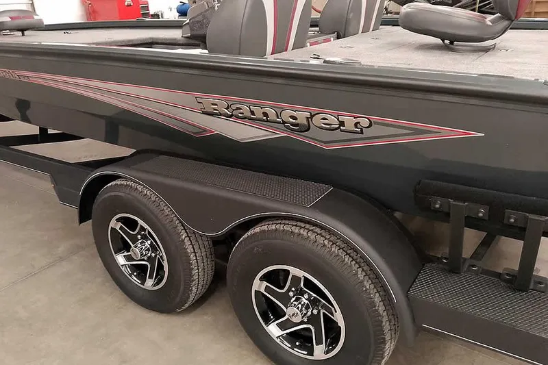 Slide: The Image of 2025 Ranger ALPHA 208 boat on trailer with dual wheels in a garage setting. - 11