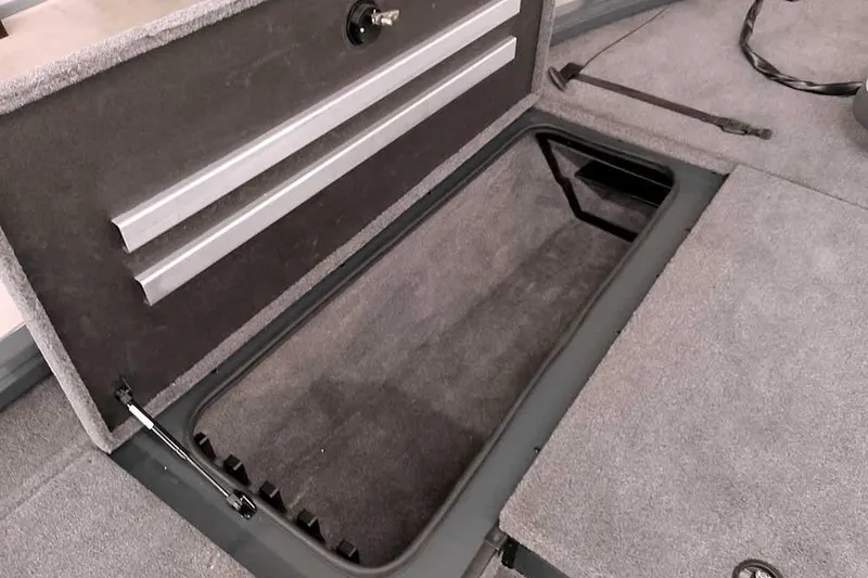 Slide: The Image of Open storage compartment in 2025 Ranger ALPHA 208 boat, featuring carpeted interior and secure latch. - 18