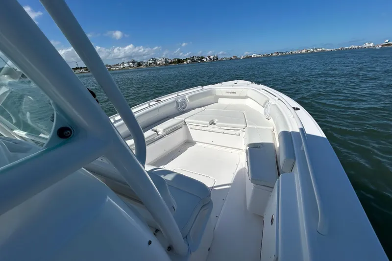 Slide: The Image of 2016 Everglades 243 Center Console boat on water, clear sky, coastal view. - 13