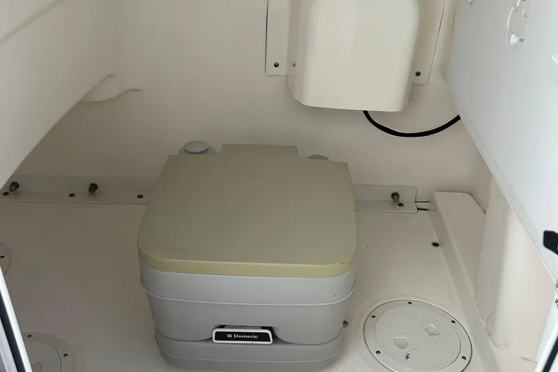 Slide: The Image of 2016 Everglades 243 Center Console boat on calm water, clear sky background. - 16