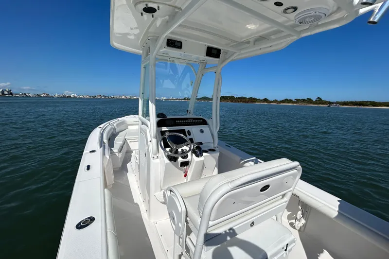 Slide: The Image of 2016 Everglades 243 Center Console boat interior with seating and motor on water. - 6