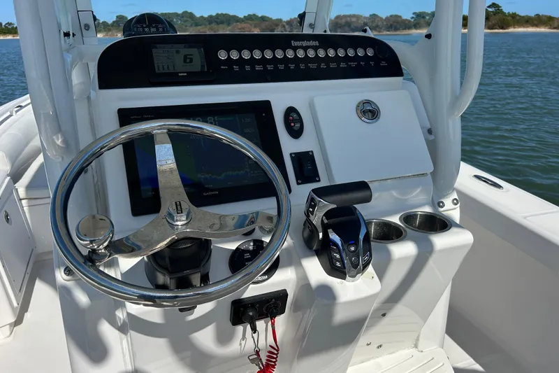 Slide: The Image of 2016 Everglades 243 Center Console boat interior with steering wheel and seating on water. - 8