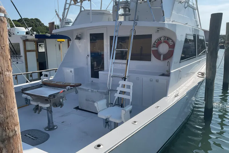 Slide: The Image of 1989 Torres 43 boat docked, featuring fishing equipment and a life preserver on deck. - 3