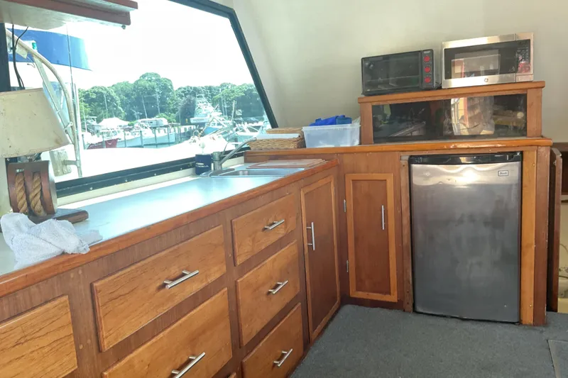 Slide: The Image of Wooden kitchen interior on a 1989 Torres 43 boat, featuring cabinets, sink, and appliances. - 9