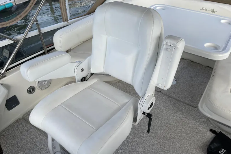 Slide: The Image of White captain's chair on 2000 Sea Ray 400 Sedan Bridge yacht, with armrests and carpeted deck. - 12