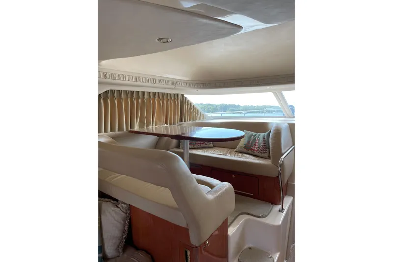 Slide: The Image of Interior of 2000 Sea Ray 400 Sedan Bridge with cozy seating and round table. - 21