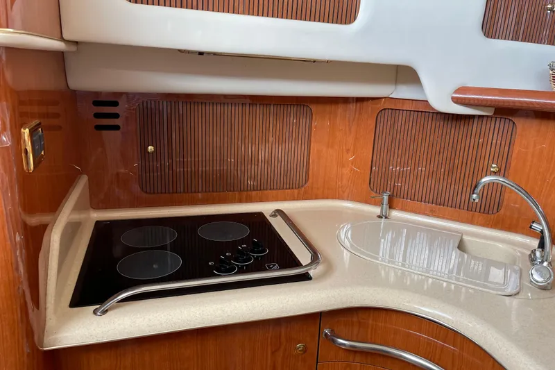 Slide: The Image of Kitchen area of 2000 Sea Ray 400 Sedan Bridge with stove and sink. - 22