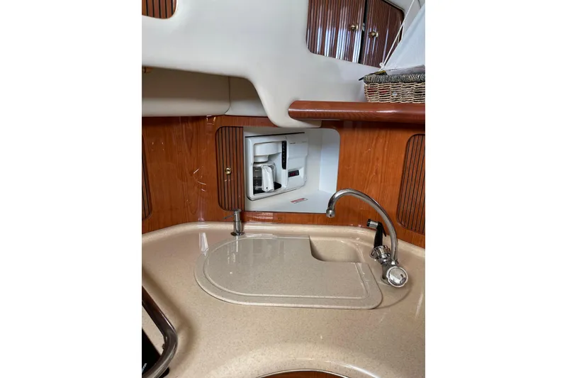 Slide: The Image of 2000 Sea Ray 400 Sedan Bridge kitchen with sink and built-in coffee maker. - 24