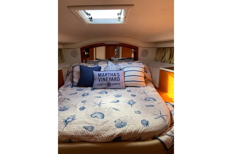 Slide: The Image of Cozy bedroom in 2000 Sea Ray 400 Sedan Bridge with nautical-themed bedding. - 25