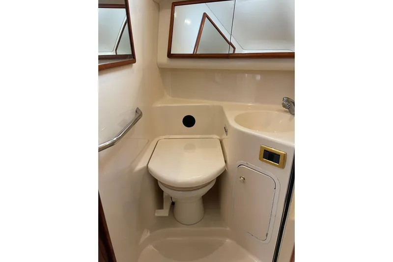 Slide: The Image of 2000 Sea Ray 400 Sedan Bridge bathroom with toilet, sink, and mirrored cabinet. - 34