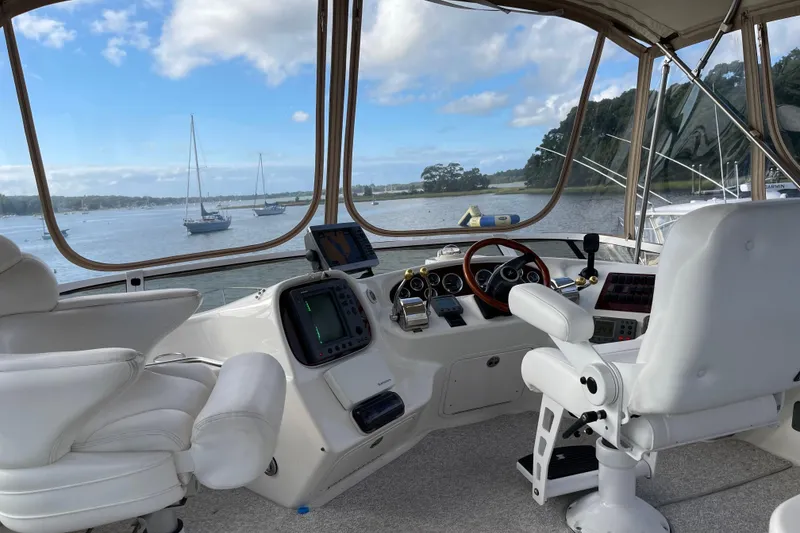 Slide: The Image of Interior view of 2000 Sea Ray 400 Sedan Bridge yacht cockpit with scenic water backdrop. - 5