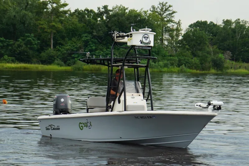 Slide: The Image of 2020 Sea Chaser 23 LX boat cruising on a calm lake with lush green background. - 1