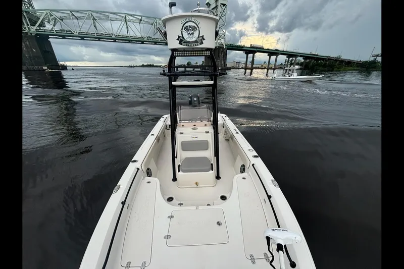 Slide: The Image of 2020 Sea Chaser 23 LX boat on water near a bridge under cloudy skies. - 12