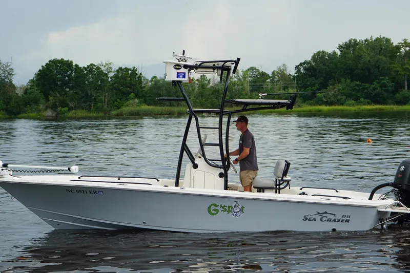 Slide: The Image of 2020 Sea Chaser 23 LX boat on calm water with lush green background. - 5