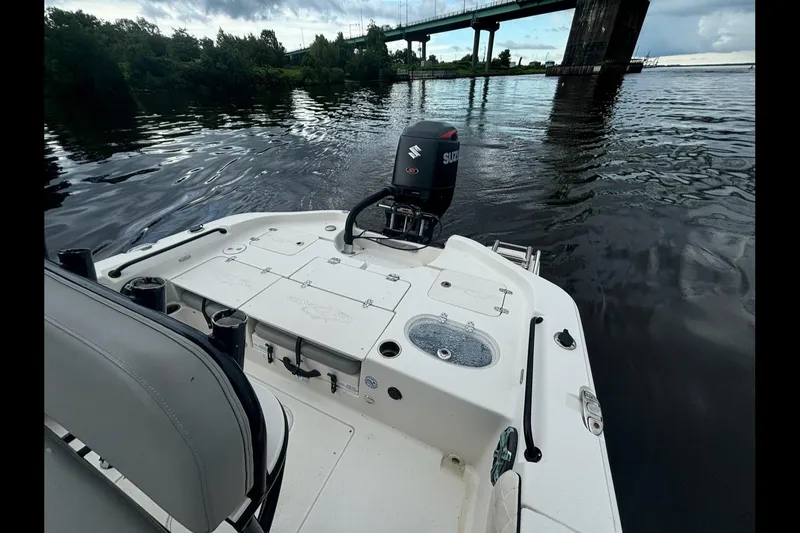 Slide: The Image of 2020 Sea Chaser 23 LX boat on water near a bridge, featuring Suzuki outboard motor. - 9