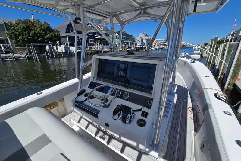 Slide: The Image of 2004 SeaVee 340B boat cockpit with steering wheel, navigation screens, and waterfront view. - 10