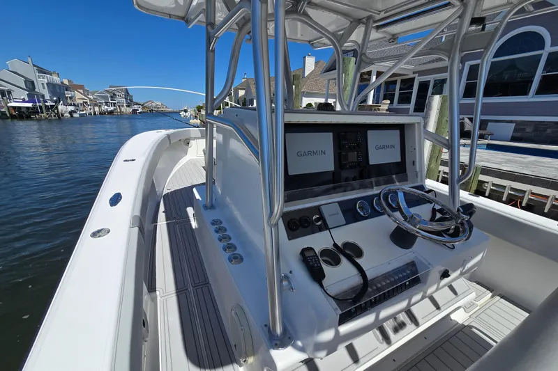 Slide: The Image of 2004 SeaVee 340B boat with Garmin navigation, docked in a scenic waterfront area. - 12