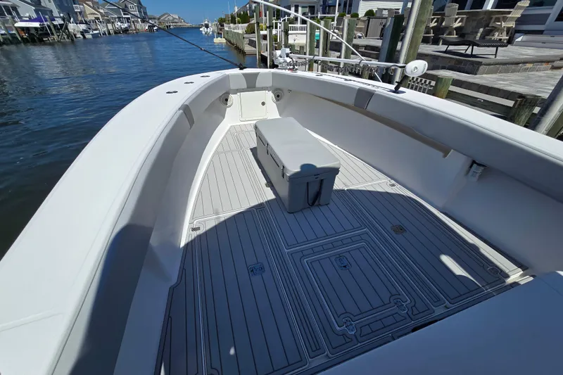 Slide: The Image of 2004 SeaVee 340B boat interior with spacious deck and seating, docked by waterfront homes. - 19
