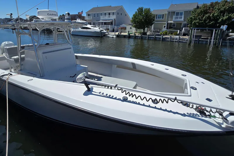 Slide: The Image of 2004 SeaVee 340B boat docked in a residential marina, featuring a sleek white design. - 2
