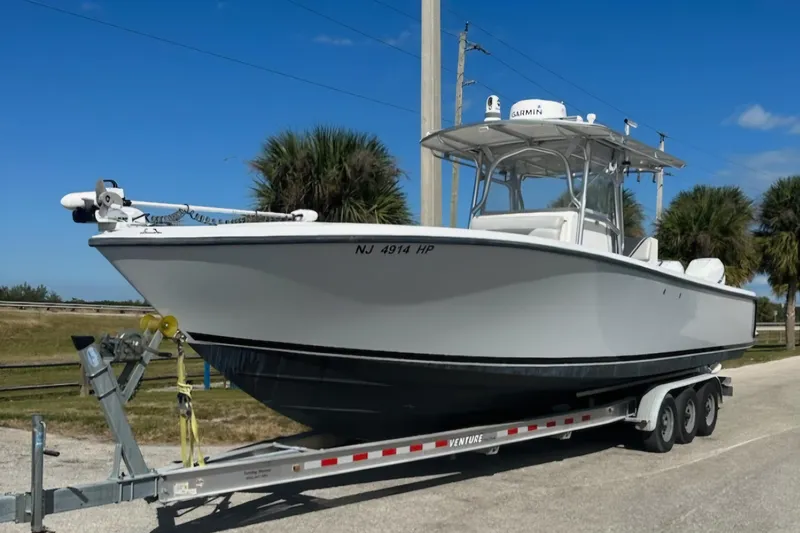 Slide: The Image of 2004 SeaVee 340B boat on trailer, parked outdoors under clear blue sky. - 4