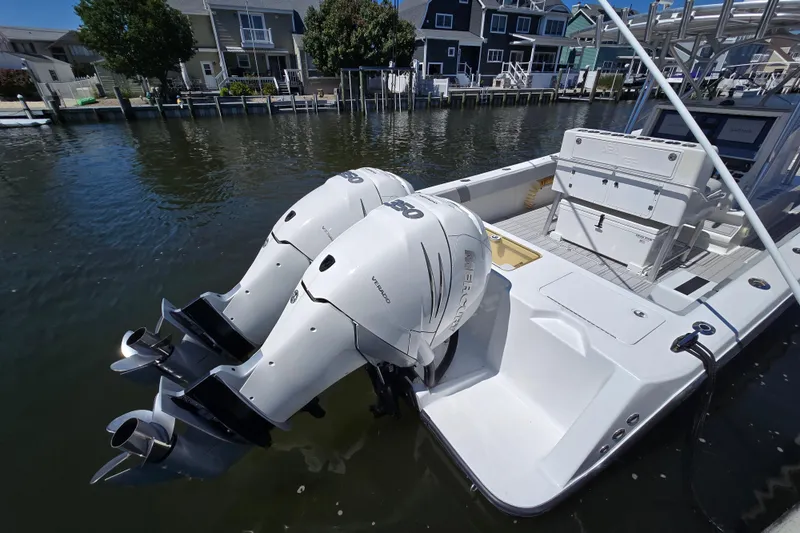 Slide: The Image of 2004 SeaVee 340B boat with dual Mercury outboard engines docked by waterfront homes. - 6