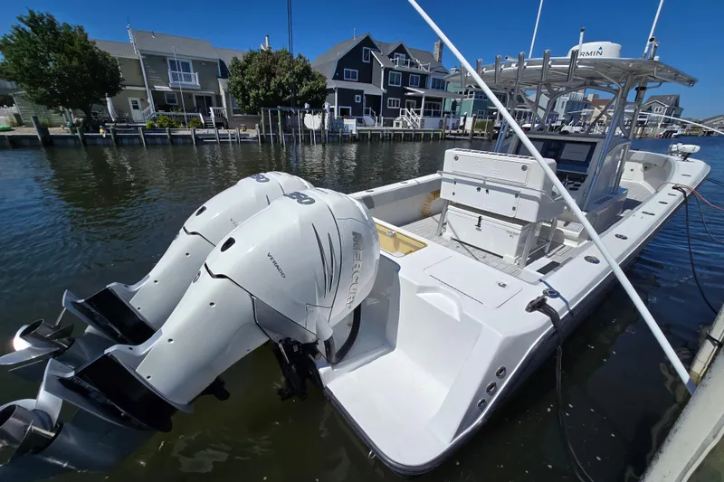 Slide: The Image of 2004 SeaVee 340B boat with twin Mercury engines docked in a residential canal. - 7