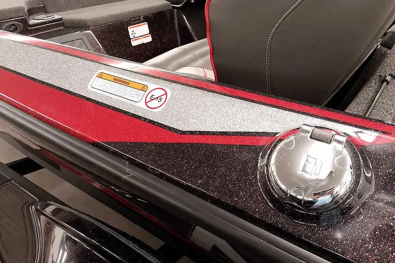 Slide: The Image of 2022 Nitro Z19 SC boat interior with red and silver detailing, fuel cap, and warning label. - 13