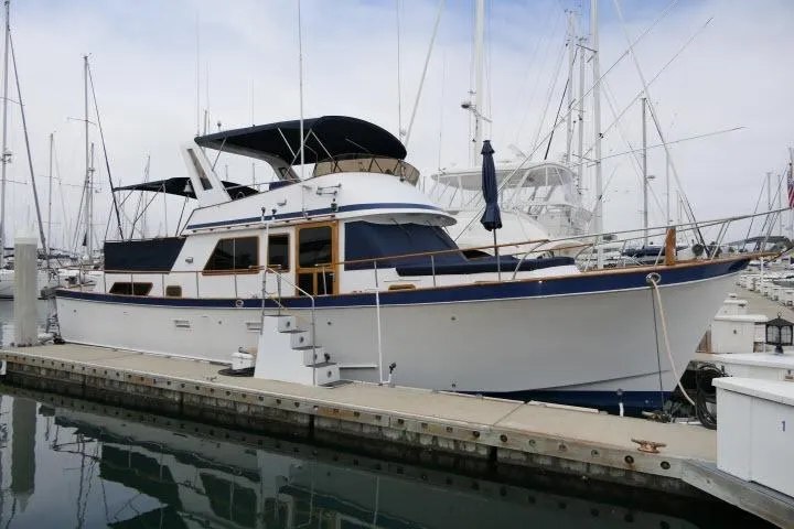 The Image of 1983 CHB 45 yacht docked at marina, featuring classic design and spacious deck. - 1