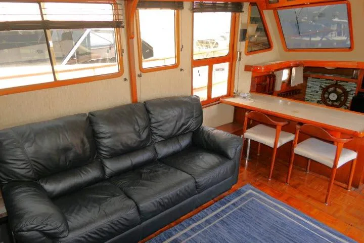 Slide: The Image of Interior of 1983 CHB 45 yacht with black leather sofa and dining area. - 10
