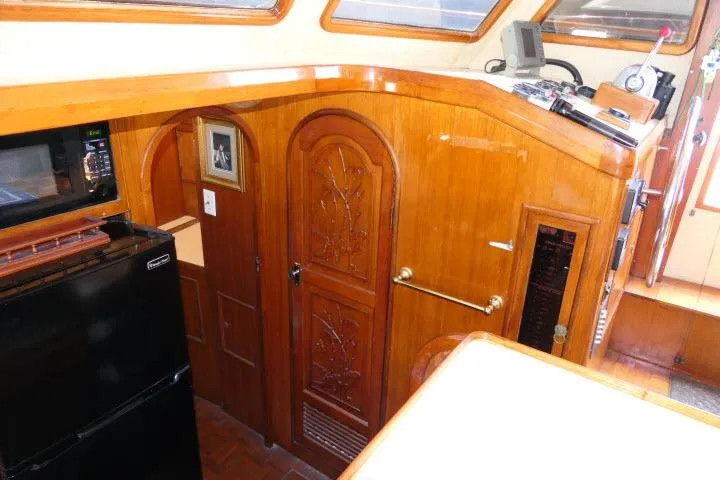 Slide: The Image of Interior of 1983 CHB 45 boat with wood paneling, microwave, and fridge. - 17