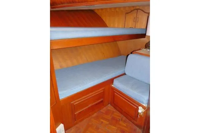 Slide: The Image of Interior of 1983 CHB 45 boat with wooden bunk beds and blue cushions. - 21